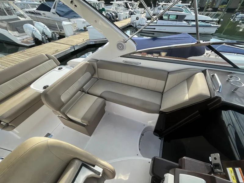 Slide: The Image of 2013 Regal 30 Express boat interior with beige seating and docked boats in background. - 8