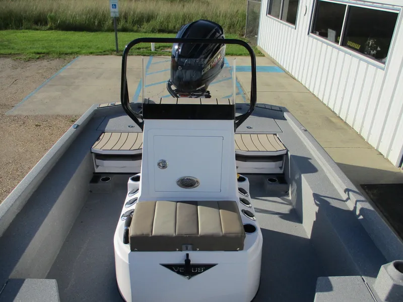 Slide: The Image of 2025 Vexus ACX 2150 boat interior with seating and motor, parked near a building. - 11