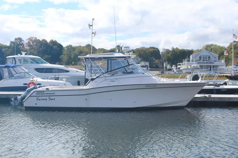 Slide: The Image of 2001 Grady-White Express 330 boat docked in a marina, surrounded by other vessels. - 1
