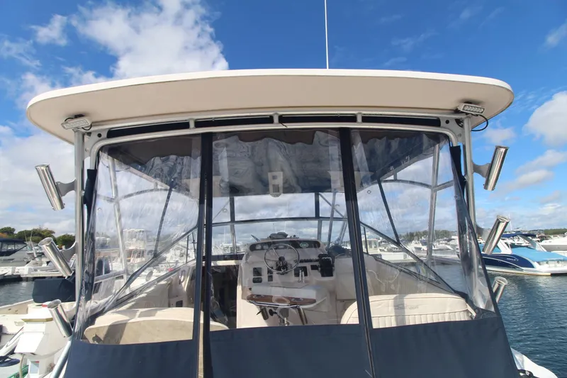 Slide: The Image of 2001 Grady-White Express 330 boat with clear enclosure, docked under blue sky. - 15