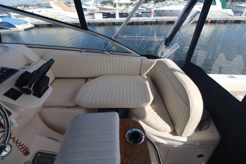 Slide: The Image of 2001 Grady-White Express 330 boat interior with cream seating and helm, docked at marina. - 17