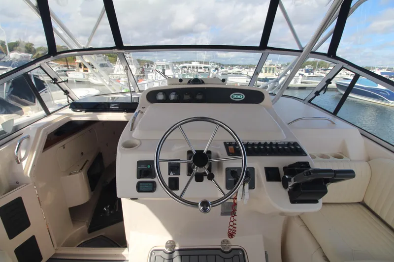 Slide: The Image of 2001 Grady-White Express 330 helm with steering wheel and control panel, docked at marina. - 18