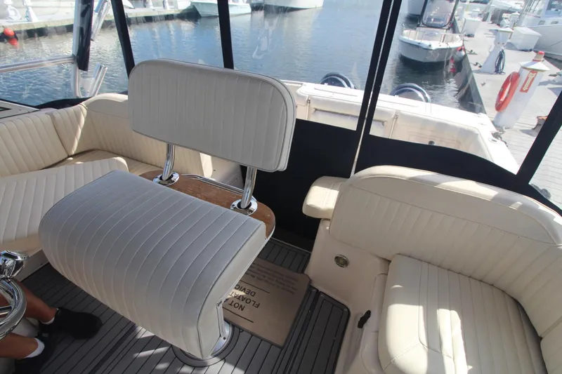 Slide: The Image of Interior of 2001 Grady-White Express 330 boat with white seating and marina view. - 27