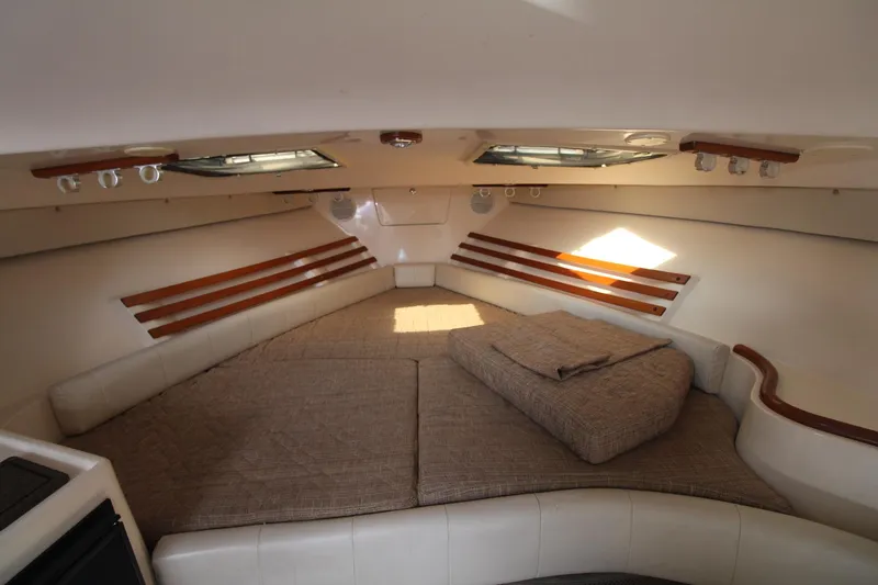 Slide: The Image of 2001 Grady-White Express 330 cabin interior with cushioned seating and wooden accents. - 29