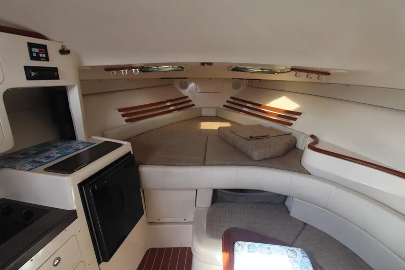Slide: The Image of 2001 Grady-White Express 330 cabin interior with cozy seating and compact kitchen area. - 31