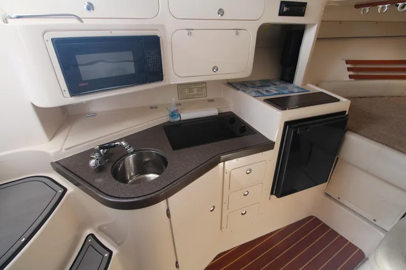 Slide: The Image of 2001 Grady-White Express 330 boat interior with kitchenette, sink, microwave, and storage cabinets. - 33