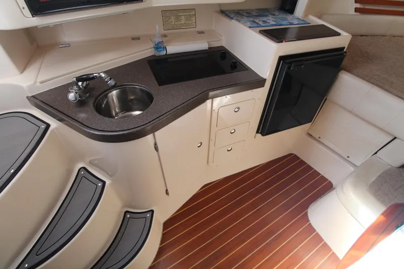 Slide: The Image of 2001 Grady-White Express 330 boat interior with kitchenette and wood flooring. - 34