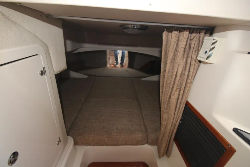 Slide: The Image of 2001 Grady-White Express 330 cabin interior with bed, curtain, and storage. - 39