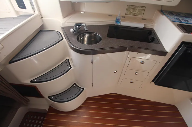 Slide: The Image of 2001 Grady-White Express 330 boat interior with kitchenette, sink, and wooden flooring. - 42
