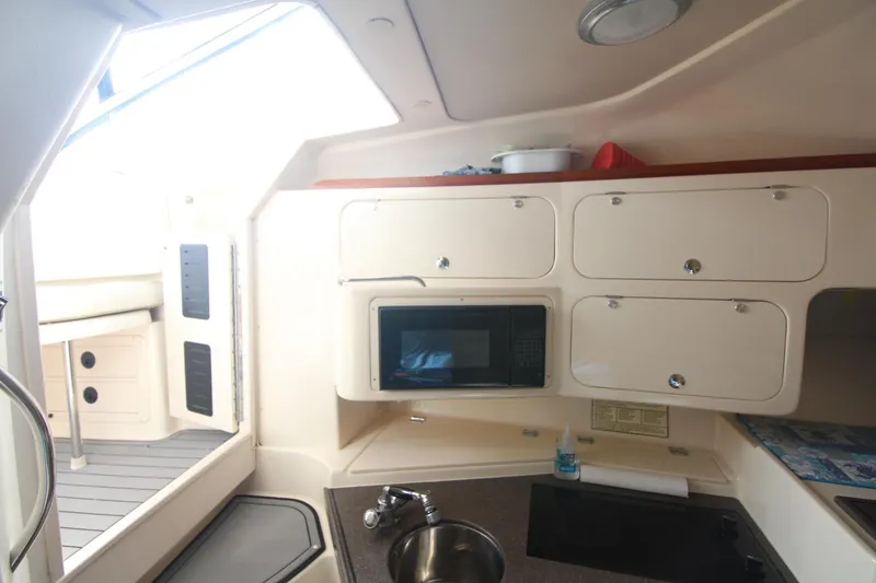 Slide: The Image of 2001 Grady-White Express 330 boat interior with kitchenette, microwave, and storage cabinets. - 43