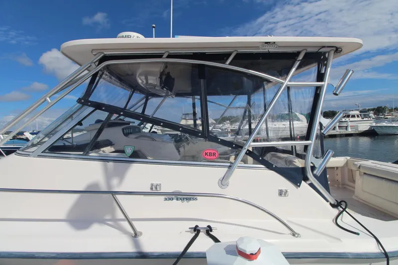 Slide: The Image of 2001 Grady-White Express 330 boat docked, featuring sleek design and clear skies. - 9