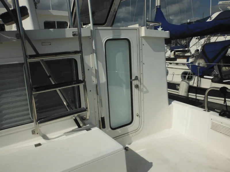 Slide: The Image of 2005 Nordic Tug 32 boat deck with ladder and door, docked at marina. - 16