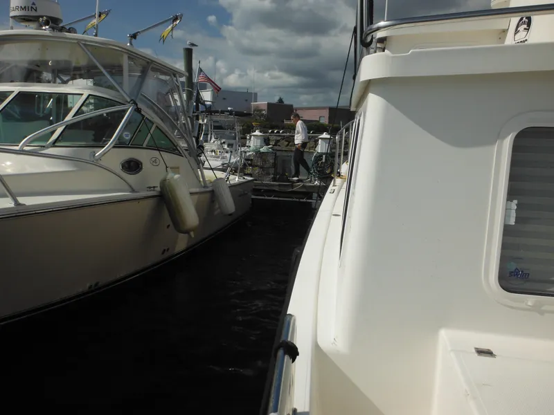 Slide: The Image of Nordic Tug 32 (2005) docked beside another boat under cloudy skies. - 17
