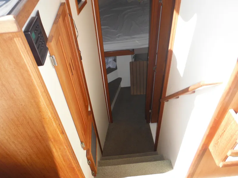 Slide: The Image of Interior view of 2005 Nordic Tug 32, featuring wooden stairs and cozy cabin space. - 29