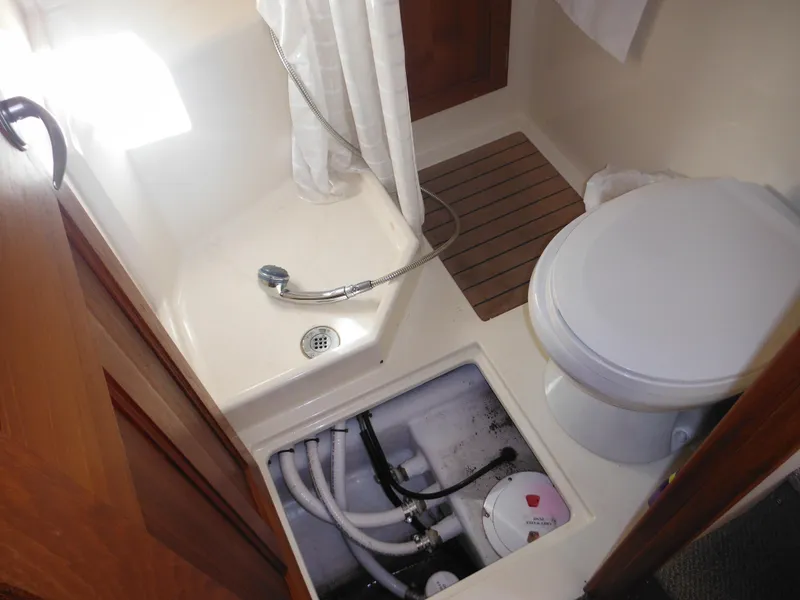 Slide: The Image of 2005 Nordic Tug 32 bathroom with shower, toilet, and plumbing access. - 34