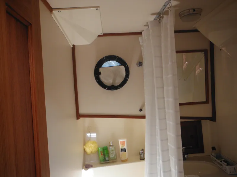 Slide: The Image of Bathroom interior of 2005 Nordic Tug 32 with porthole and shower curtain. - 37