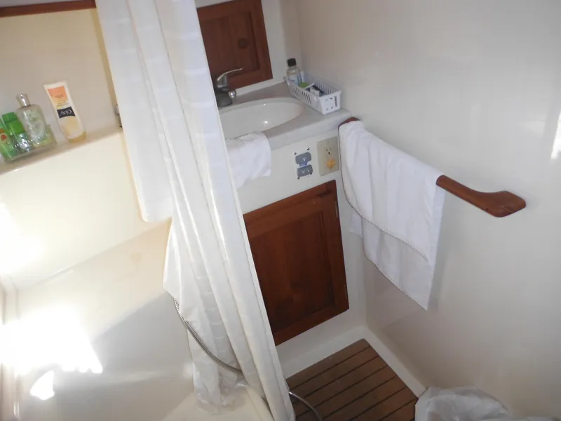 Slide: The Image of Bathroom interior of 2005 Nordic Tug 32 with sink, shower, and wooden accents. - 39