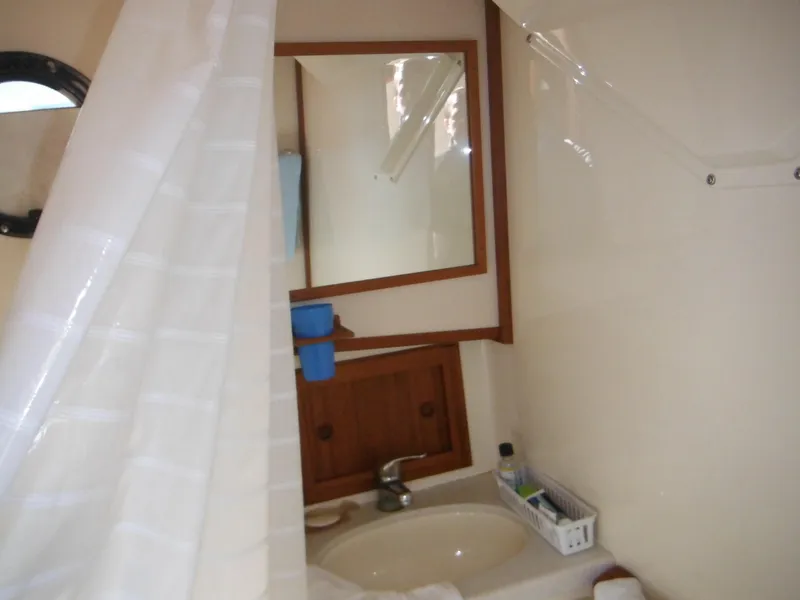 Slide: The Image of Bathroom interior of 2005 Nordic Tug 32 with sink, mirror, and shower curtain. - 40