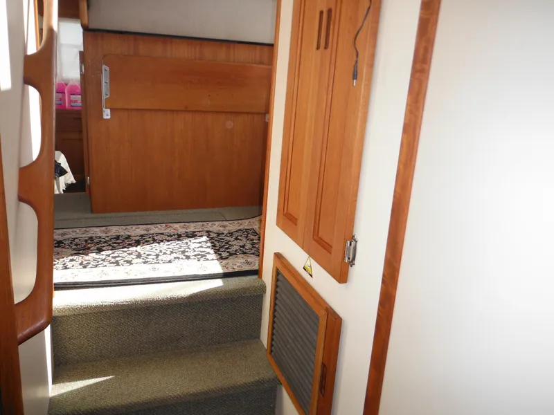 Slide: The Image of Interior of 2005 Nordic Tug 32, featuring wooden cabinetry and carpeted steps. - 49