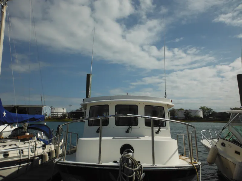 Slide: The Image of 2005 Nordic Tug 32 docked under a partly cloudy sky. - 5