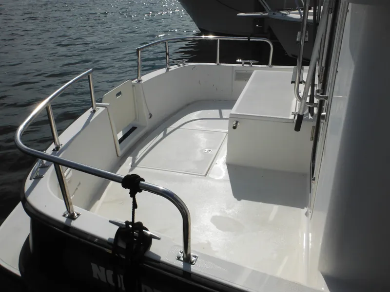 Slide: The Image of 2005 Nordic Tug 32 boat deck with railing, docked on calm water. - 6