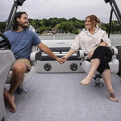 Slide: The Image of Couple holding hands on a 2023 Harris 230 Sunliner boat, enjoying a scenic lake view. - 3