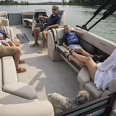 Slide: The Image of Family relaxing on a 2023 Harris 230 Sunliner pontoon boat on a lake. - 4