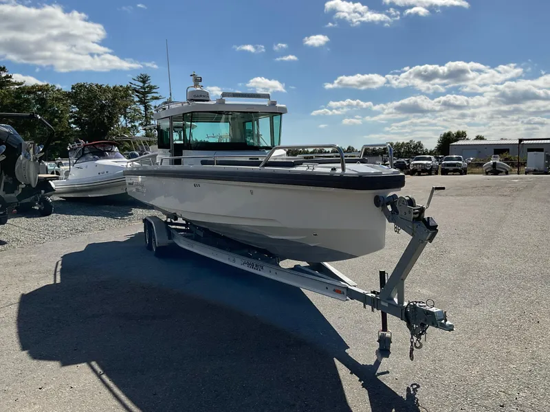 Slide: The Image of 2020 Axopar 28 boat on trailer under a sunny sky. - 1