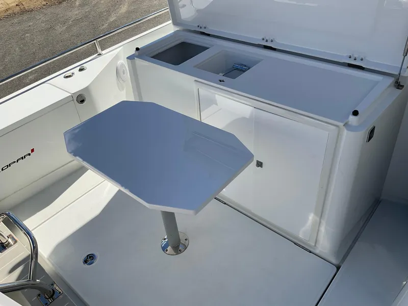 Slide: The Image of Axopar 28 boat interior, 2020 model, featuring a sleek white table and storage compartments. - 10