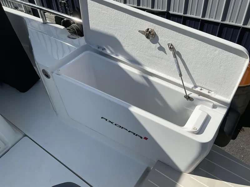 Slide: The Image of Axopar 28 boat storage compartment, 2020 model, open lid, white interior. - 12
