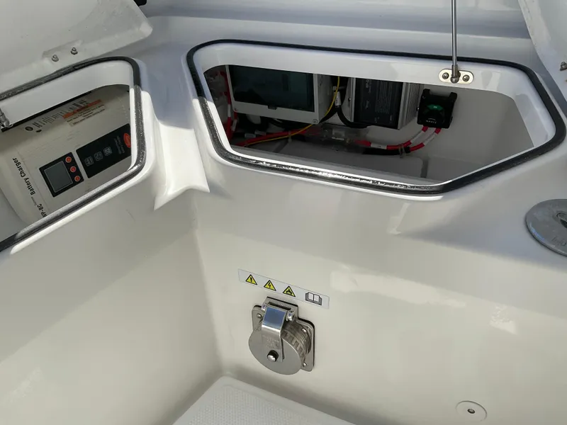 Slide: The Image of Axopar 28 boat interior, 2020 model, showing storage compartment and electrical components. - 17