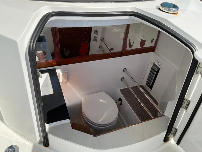 Slide: The Image of 2020 Axopar 28 boat interior with compact bathroom and toilet. - 23