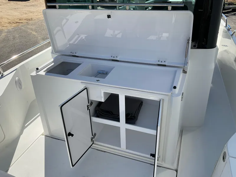 Slide: The Image of 2020 Axopar 28 boat with open storage compartment and sink. - 25