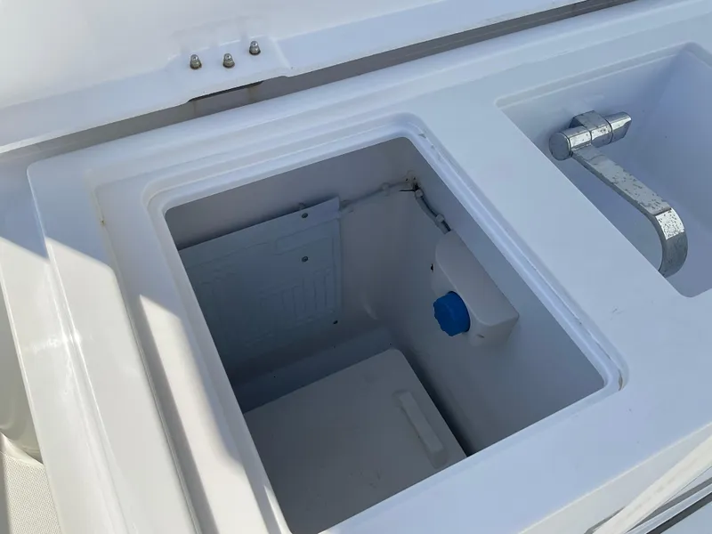 Slide: The Image of Axopar 28 (2020) boat sink and storage compartment, white interior. - 26