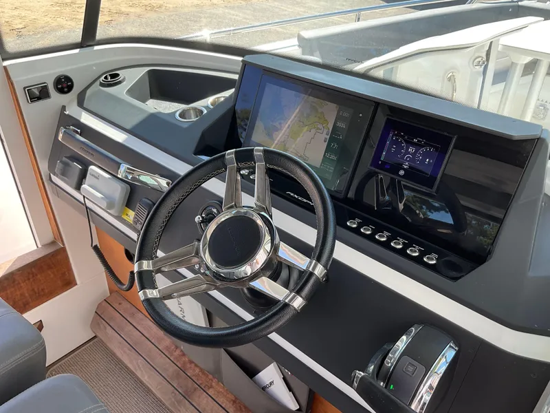 Slide: The Image of 2020 Axopar 28 boat dashboard with steering wheel and navigation screens. - 28