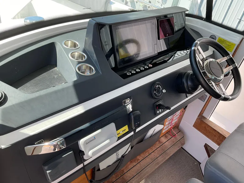 Slide: The Image of 2020 Axopar 28 boat dashboard with steering wheel and navigation controls. - 29