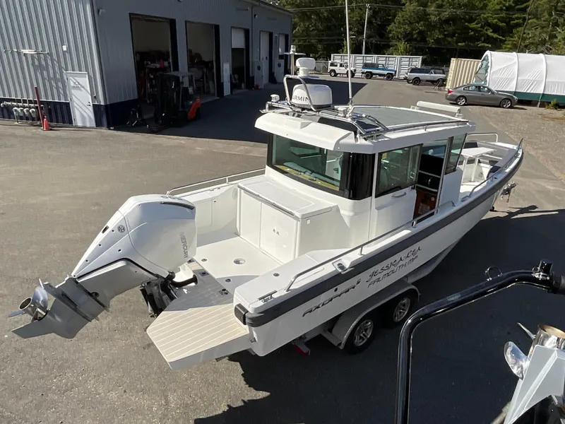 Slide: The Image of 2020 Axopar 28 boat on trailer, parked outside a garage. - 4