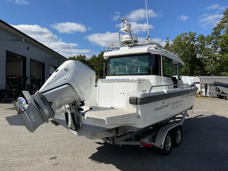 Slide: The Image of 2020 Axopar 28 boat on trailer, featuring powerful outboard motor, parked outdoors. - 6