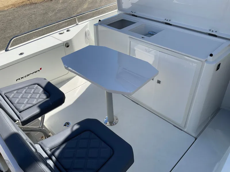 Slide: The Image of 2020 Axopar 28 boat interior with seating and table setup. - 7