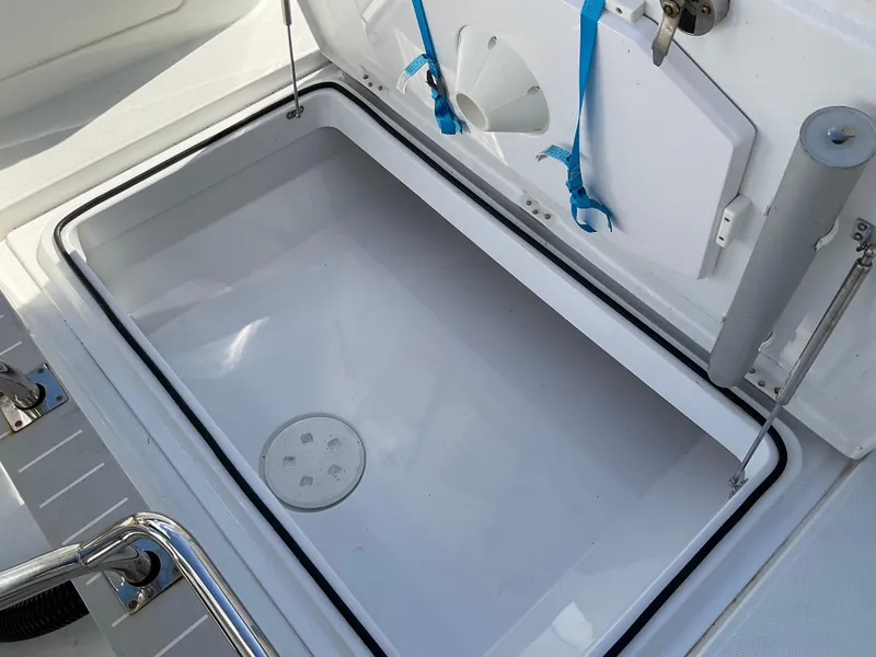 Slide: The Image of Open storage compartment on 2020 Axopar 28 boat, featuring hydraulic lift and secure latches. - 9