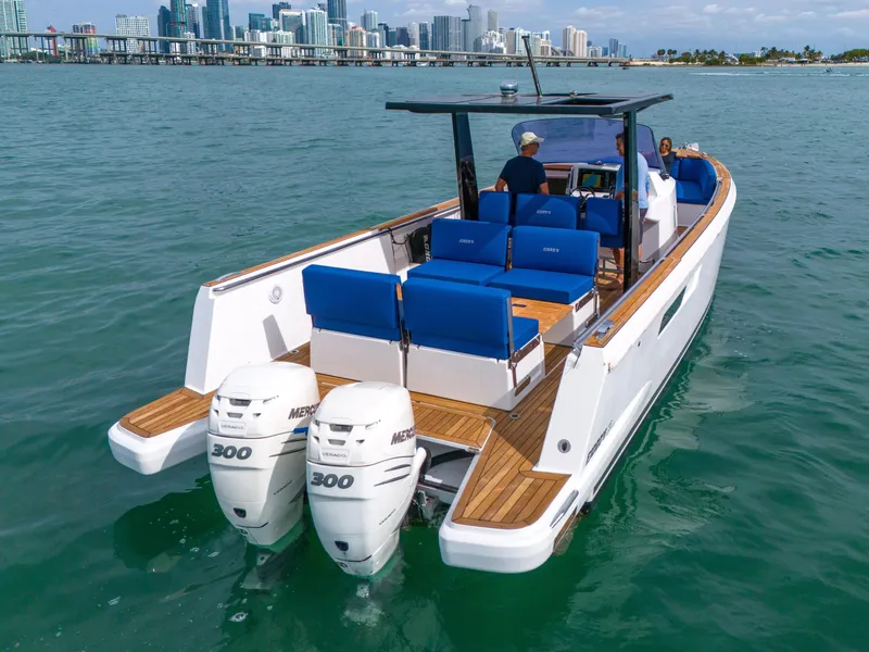 Slide: The Image of 2019 Fjord 38 Xpress boat with twin Mercury 300 engines on water, city skyline in background. - 20