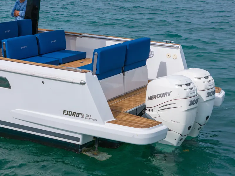 Slide: The Image of 2019 Fjord 38 Xpress boat with twin Mercury 300 engines, featuring blue seating on deck. - 30