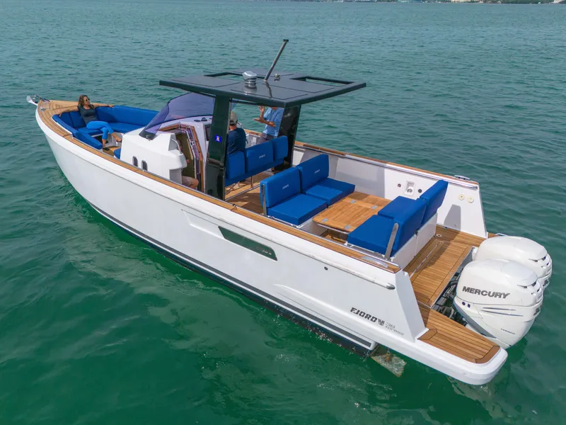 Slide: The Image of 2019 Fjord 38 Xpress boat with blue seating, cruising on clear water. - 32