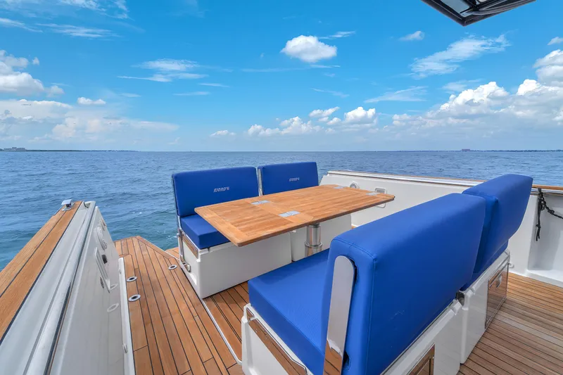 Slide: The Image of 2019 Fjord 38 Xpress boat with blue seating and wooden deck on open water. - 40