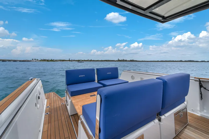 Slide: The Image of 2019 Fjord 38 Xpress boat with blue seating, wooden deck, and ocean view. - 48