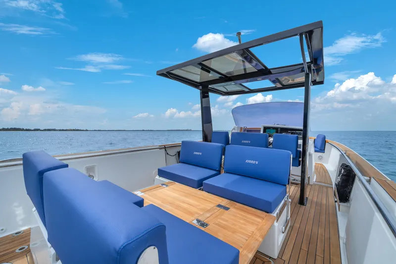Slide: The Image of 2019 Fjord 38 Xpress boat with blue seating, wooden deck, and ocean view. - 49