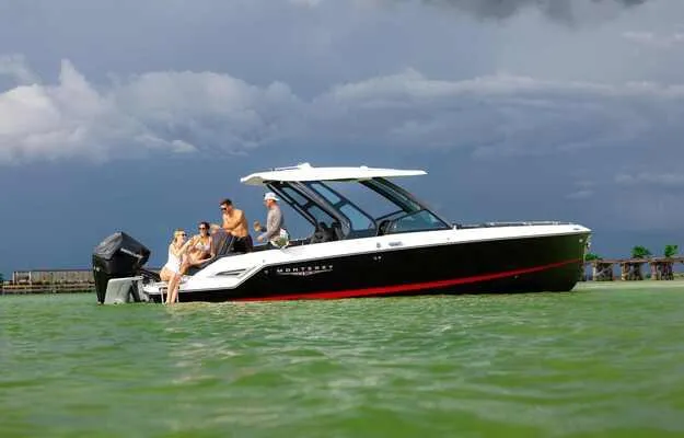 Slide: The Image of 2025 Monterey Elite 30 OB boat on water with passengers enjoying a scenic view. - 12