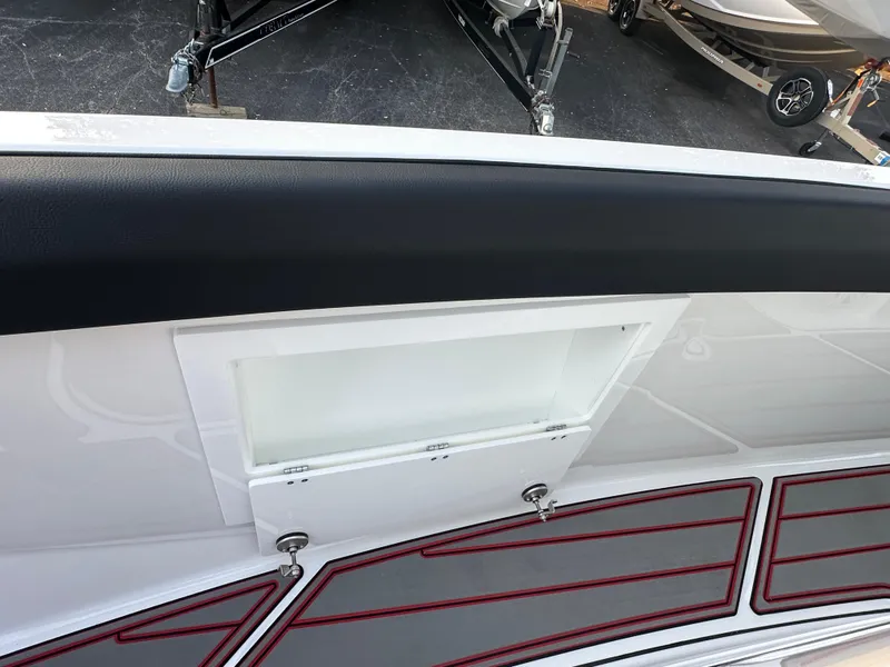 Slide: The Image of 2025 Monterey Elite 30 OB boat interior with storage compartment and red-trimmed flooring. - 31