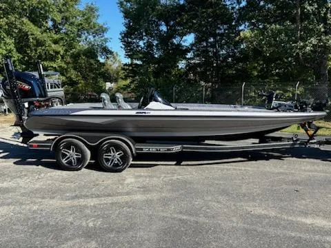 The Image of 2025 Skeeter ZXR 21 boat on trailer, parked outdoors with trees in the background. - 1