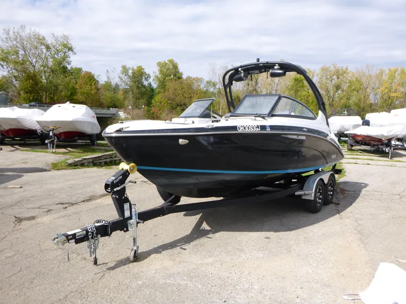 Slide: The Image of 2021 Yamaha Boats 212S on trailer, black hull, parked outdoors. - 4